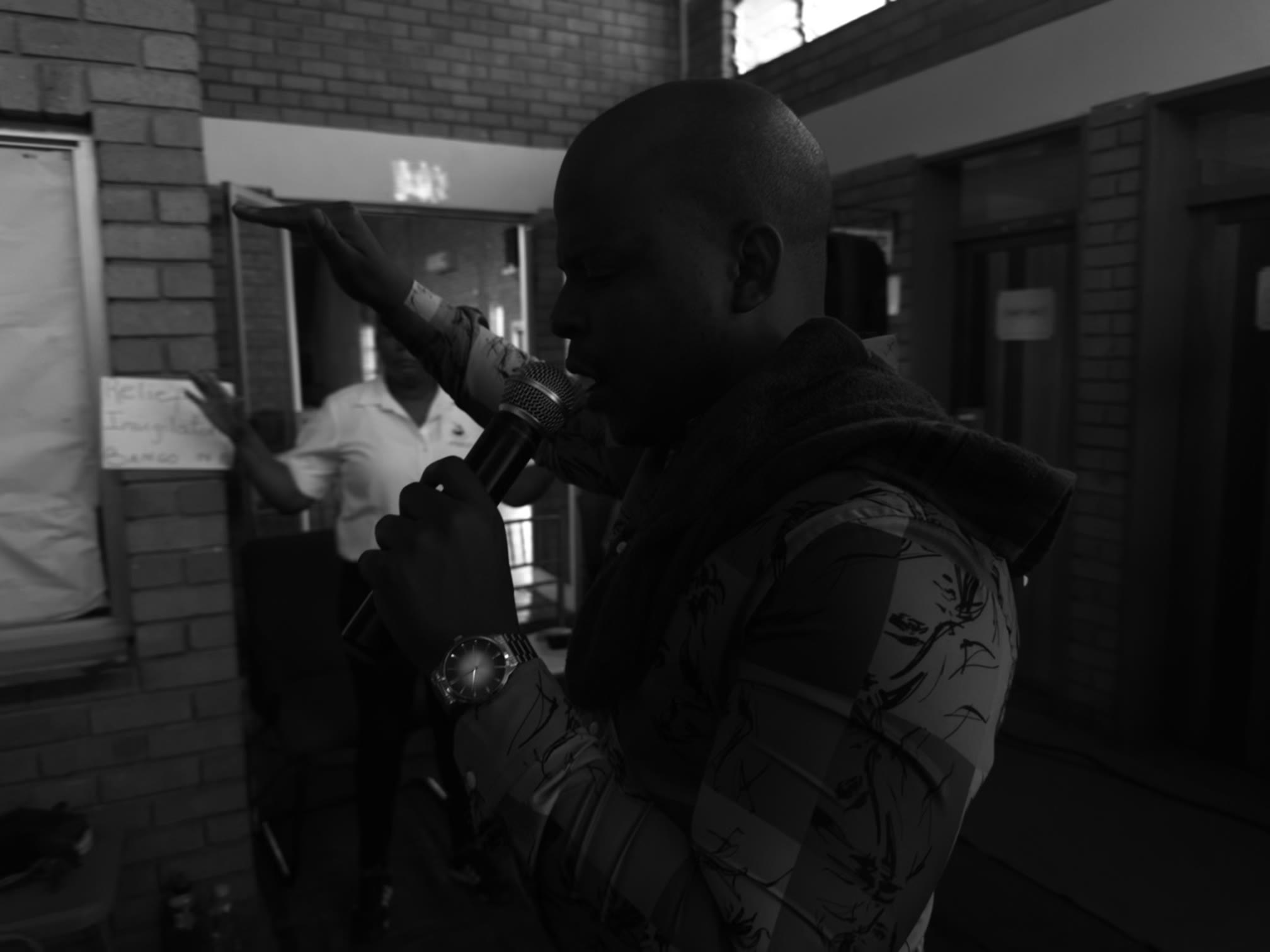 Prophet Matimba Nyandane ministering with a microphone and one hand raised