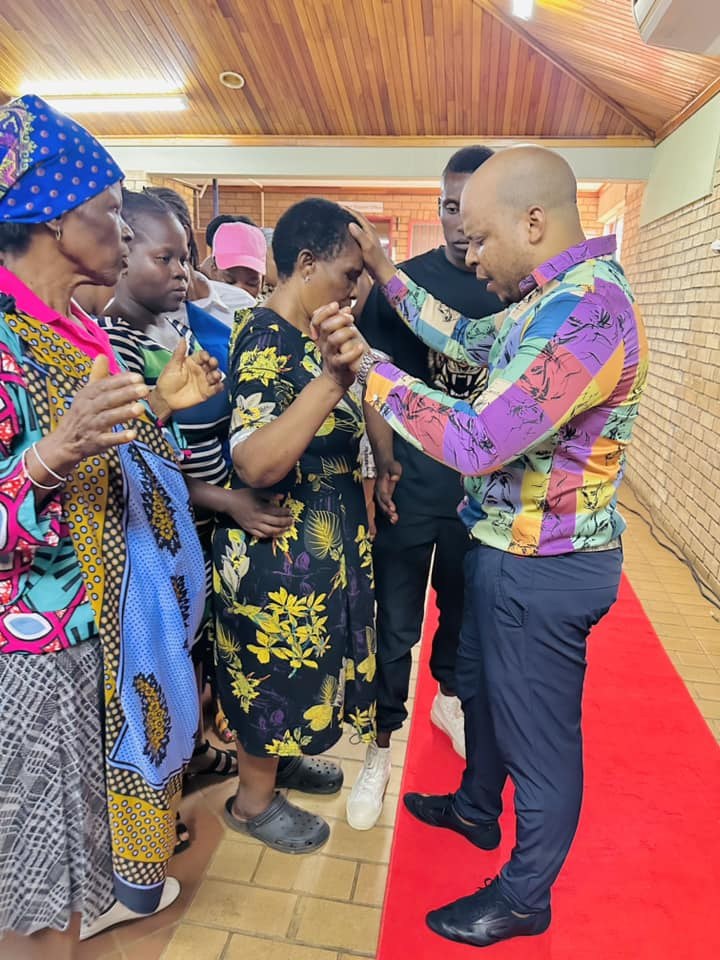 Prophet Matimba Nyandane praying with a woman during a Heavenly Grace gathering